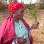 African woman with a cellphone at her corn farm. Photo courtesy: www.kilimosalama.wordpress.com